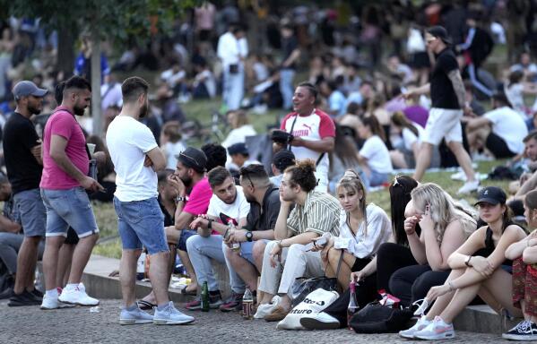 People are seen at the "Monbijoupark" (Monbijou Park) during a warm summer evening in Berlin, Germany, Friday, June 11, 2021. (AP Photo/Michael Sohn)