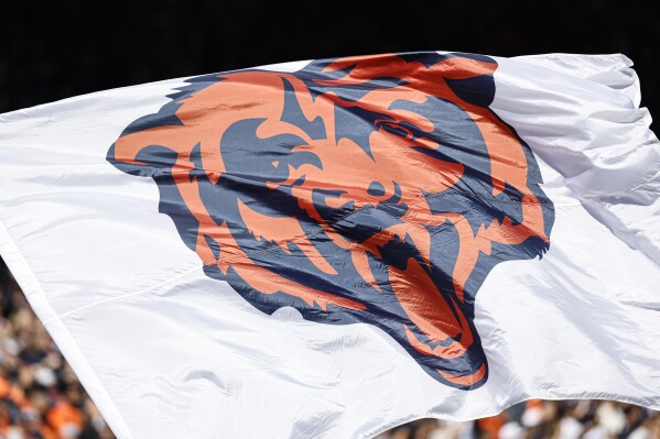 FILE - The Chicago Bears logo is pictured on a flag prior to an NFL football game between the Chicago Bears and Denver Broncos, Oct. 1, 2023, in Chicago. The Chicago Bears have scheduled a Wednesday, April 24, 2024, news conference to announce plans for “a state-of-the-art, publicly owned enclosed stadium” on the city's Museum Campus near Lake Michigan. The announcement Monday, April 22, said the plans also call for additional green and open space with access to the lakefront. (AP Photo/Kamil Krzaczynski, File)