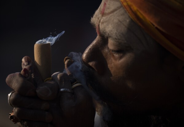A holy man smokes marijuana at the Pashupatinath temple premises during Shivaratri festival in Kathmandu, Nepal, Friday, March 8, 2024. (AP Photo/Niranjan Shrestha)