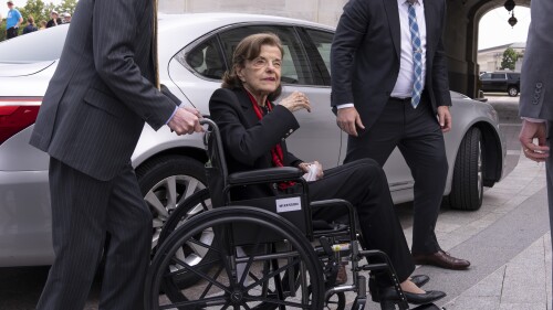FILE - Sen. Dianne Feinstein, D-Calif., is assisted in a wheelchair by staff as she returns to the Senate floor after an absence of more than two months, at the Washington Capitol on May 10, 2023. Lawyers for Feinstein, the most senior member of Congress with serious health problems, asserted in court filing Monday, July 17, that her fortune was 