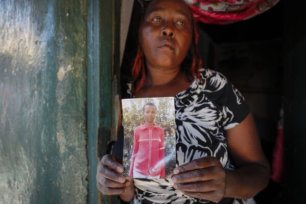Rose Wanyua Wanjiku, elder sister to Agnes Wanjiru, 20, holds a photograph of Agnes, at Rose's house in the Majengo informal settlement in Nanyuki, Kenya Thursday, Nov. 4, 2021. (AP Photo/Brian Inganga)
