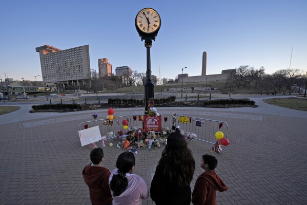 FILE - People view a memorial, Sunday, Feb. 18, 2024, in Kansas City, Mo., dedicated to the victims of a shooting at the Kansas City Chiefs NFL football Super Bowl celebration. Three men from Kansas City, Mo.,, face firearms charges, including gun trafficking, after an investigation into the mass shooting during the Kansas City Chiefs’ Super Bowl parade and rally, federal prosecutors said Wednesday, March 13, 2024. (AP Photo/Charlie Riedel, File)