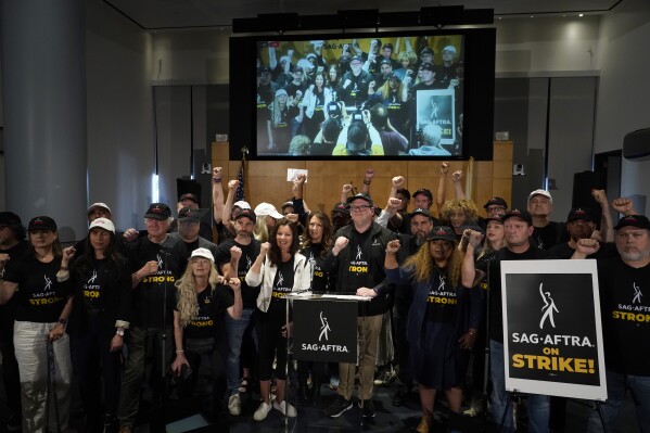 SAG-AFTRA president Fran Drescher and SAG-AFTRA National Executive Director and Chief Negotiator Duncan Crabtree-Ireland, center, pose with SAG-AFTRA members during a press conference announcing a strike by The Screen Actors Guild-American Federation of Television and Radio Artists on Thursday, July, 13, 2023, in Los Angeles. This marks the first time since 1960 that actors and writers will picket film and television productions at the same time. (AP Photo/Chris Pizzello)