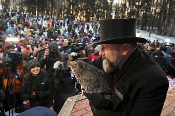 FILE - Groundhog Club handler A.J. Dereume holds Punxsutawney Phil, the weather prognosticating groundhog, during the 137th celebration of Groundhog Day on Gobbler's Knob in Punxsutawney, Pa., Feb. 2, 2023. The arrival of annual Groundhog Day celebrations Friday, Feb. 2, 2024, will draw thousands of people to see celebrity woodchuck Phil at Gobbler's Knob in Punxsutawney, Pa. 鈥� an event that exploded in popularity after the 1993 Bill Murray movie. (APPhoto/Barry Reeger, File)