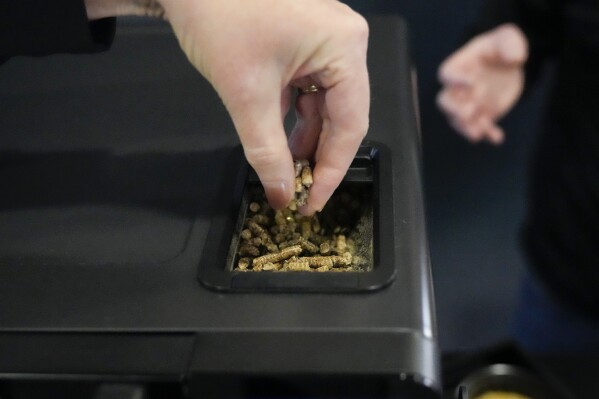 Laura Hammond, GE Profile, displays the wooden pellets used in the company's new electric and smokeless smoker during the CES tech show Wednesday, Jan. 10, 2024, in Las Vegas. (AP Photo/Ryan Sun)