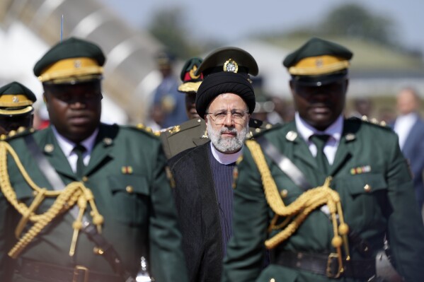 Iran's President Ebrahim Raisi, center, inspects the guard of honour upon his arrival at Robert Mugabe airport in Harare, Zimbabwe, Thursday, July 13, 2023. Iran's president is on a rare visit to Africa as the country, which is under heavy U.S. economic sanctions, seeks to deepen partnerships around the world. (AP Photo/Tsvangirayi Mukwazhi)