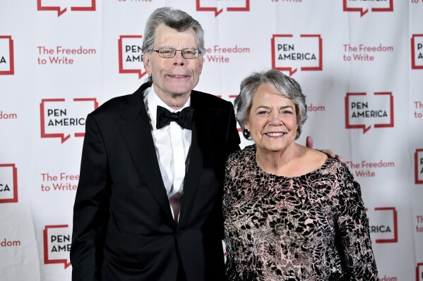 FILE - In this May 22, 2018 file photo, PEN literary service award recipient Stephen King poses with Simon & Schuster president Carolyn Reidy at the 2018 PEN Literary Gala at the American Museum of Natural History on in New York.  ViacomCBS, fresh off a merger, is looking to sell its Simon & Schuster book publishing business as it tries to raise cash to pay down debt and please shareholders with dividends and stock buybacks. ViacomCBS CEO Bob Bakish said the book publisher is not a “core asset” of the company since it isn't video. But he said it's a “marquee asset” that is “highly valuable.” (Photo by Evan Agostini/Invision/AP, File)