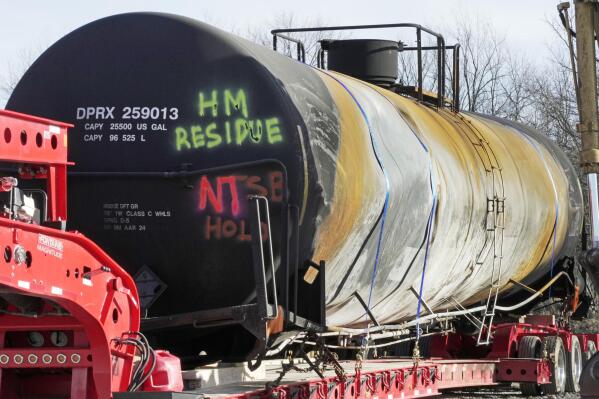 A tank car sits on a trailer as the cleanup of portions of a Norfolk Southern freight train that derailed over a week ago continues in East Palestine, Ohio, Wednesday, Feb. 15, 2023. (AP Photo/Gene J. Puskar)