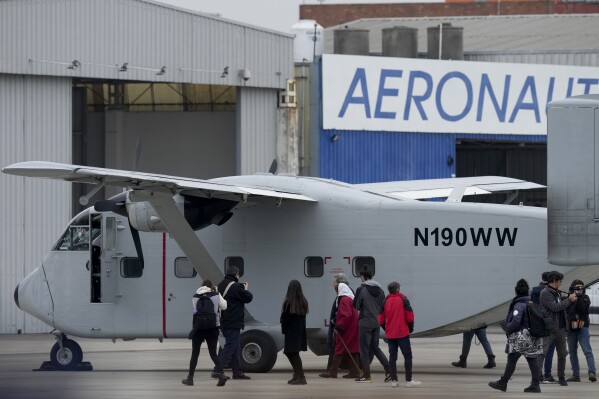 Members of human rights organizations walk alongside one of the planes that carried out "death flights," when detainees were tossed out into the sea during Argentina's last military dictatorship, on the tarmac of the Jorge Newbery international airport in Buenos Aires, Argentina, Saturday, June 24, 2023. The plane that had been located in the US arrived in Argentina's capital Saturday and will eventually be transferred to the the Museum of Memory set up in the former illegal detention center known as ESMA. (AP Photo/Natacha Pisarenko)