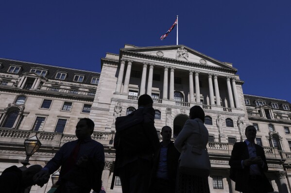People are silhouetted as they pass The Bank of England in London, Thursday, April 3, 2025. (AP Photo/Kirsty Wigglesworth, File)