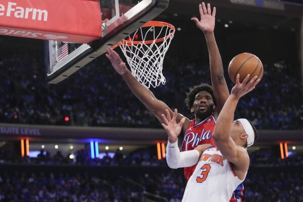 New York Knicks guard Josh Hart (3) goes to the basket against Philadelphia 76ers center Joel Embiid, top, during the second half in Game 1 of an NBA basketball first-round playoff series, Saturday, April 20, 2024, at Madison Square Garden in New York. (AP Photo/Mary Altaffer)