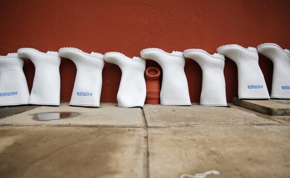 The rubber boots of medical workers stand in a line to dry after being decontaminated at an isolation and treatment center for those with COVID-19 in Machakos, south of the capital Nairobi, in Kenya Tuesday, Nov. 3, 2020. As Africa is poised to surpass 2 million confirmed coronavirus cases it is Kenya's turn to worry the continent with a second surge in infections well under way. (AP Photo/Brian Inganga)