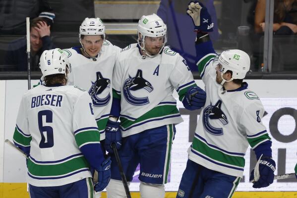 Vancouver Canucks right wing Brock Boeser (6), Matthew Highmore (15), center J.T. Miller (9) and Conor Garland (8) celebrate after Miller's overtime goal in the team's NHL hockey game against the San Jose Sharks in San Jose, Calif., Thursday, Feb. 17, 2022. (AP Photo/Josie Lepe)