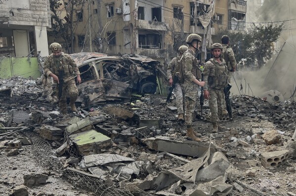Lebanese army soldiers inspect the site that was hit by an Israeli airstrike in Dahiyeh, in the southern suburb of Beirut, Lebanon, Friday March 28, 2025.(AP Photo/Hussein Malla)
