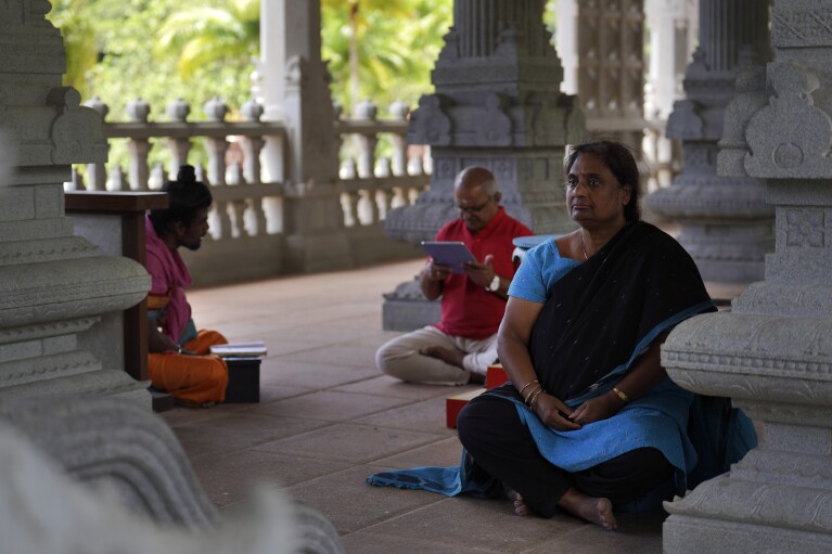 Devajyothi Kondapi, right, a pilgrim who visits from Portland, Oregon a few times a year, meditates in the Iraivan Temple as her husband practices a chant, at Kauai's Hindu Monastery on July 9, 2023, in Kapaa, Hawaii. Kondapi believes the monks, their discipline and authenticity make it "a divine place." (AP Photo/Jessie Wardarski)