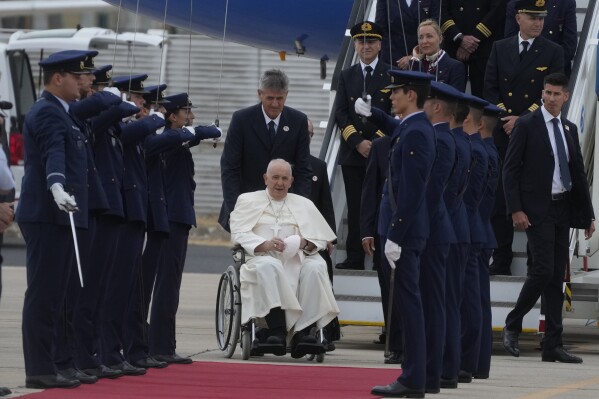 Pope Francis is welcomed by the honor guard as he arrives at the Figo Maduro airbase in Lisbon, Wednesday, Aug. 2, 2023. Pope Francis arrived Wednesday in Lisbon to attend the international World Youth Day on Sunday that is expected to bring hundreds of thousands of young Catholic faithful to Portugal. (AP Photo/Gregorio Borgia)