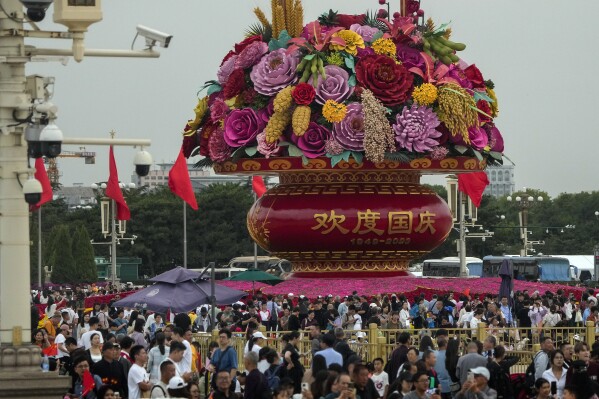 Visitors gather near a giant flower basket on display at the crowded Tiananmen Square to celebrate the 74th anniversary of the founding of the People's Republic of China, in Beijing on Thursday, Sept. 28, 2023. Tens of millions of Chinese tourists are expected to travel within their country, splurging on hotels, tours, attractions and meals in a boost to the economy during the 8-day autumn holiday period that began Friday. (AP Photo/Andy Wong)
