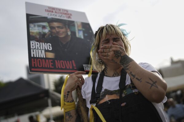 A woman cries as she gathers with others to watch a live broadcast of Israeli-American soldier Edan Alexander to be released from Hamas captivity in Gaza, at a plaza known as the hostages square in Tel Aviv, Monday, May 12, 2025. Alexander was abducted during the Hamas-led attack on his base on October 7, 2023. (AP Photo/Oded Balilty)