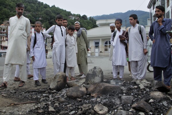 Un grupo de residentes locales en el lugar donde una turba mató y quemó a un hombre al que acusó de profanar un Corán, en Madyan, en la provincia Khyber Pakhtunkhwa del este de Pakistán, el 21 de junio del 2024. (Foto AP /Naveed Ali)