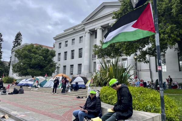 Pro-palästinensische Demonstranten versammeln sich am Dienstag, 23. April 2024, vor Sproul Hall auf dem Campus der University of California.  Einige Hochschulen ermutigen ihre Studierenden, den Unterricht aus der Ferne zu besuchen.  (AP Photo/Haven Daly)