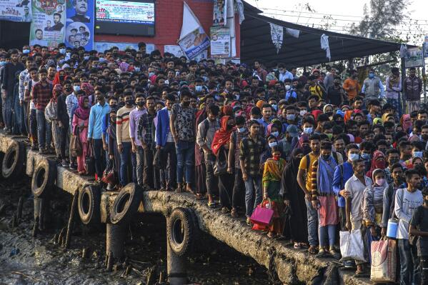 Workers gather in the morning at a boat terminal, waiting to cross the Mongla river, in Mongla, Bangladesh, March 3, 2022. This Bangladeshi town, located near the world’s largest mangrove forest Sundarbans, stands alone to offer new life to thousands of climate migrants. The town was once vulnerable to floods and river erosion. Now it has become more resilient with improved infrastructure and special economic zones to support climate migrants. (AP Photo/Mahmud Hossain Opu)