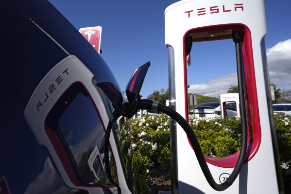 FILE - A Tesla electric vehicle is charged on May 10, 2023, in Westlake, Calif. EV sales are expected to hit a record 9% of all passenger vehicles in the U.S. this year, according to Atlas Public Policy. (AP Photo/Mark J. Terrill, File)