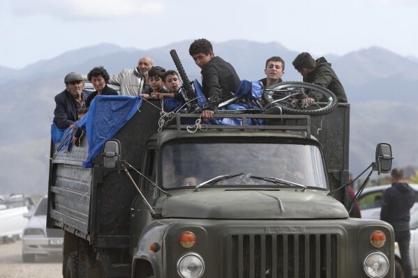 Personas de etnia armenia de Nagorno-Karabakh viajan en camión hacia Kornidzor, en la región de Syunik, Armenia, el 26 de septiembre de 2023. Miles de residentes de Nagorno-Karabakh huyen de sus hogares tras la rápida operación militar en la que Azerbaiyán recuperó el control de la región, que llevaba tres décadas gestionada por fuerzas separatistas. (Stepan Poghosyan, imagen de Photolure via AP)