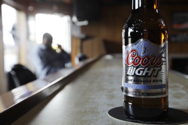 FILE - In this Monday, May 4, 2009, file photo, a bottle of Coors Light sits on the bar as a patron sips a beer at a tavern in Blue Island, Ill. Molson Coors Beverage Co. says it has been hit by a cyberattack that disrupted its brewing operations and shipments. In a regulatory filing Thursday, March 11, 2021, the Chicago-based company said it has hired forensic information technology firms to help it investigate the incident and is working to get its systems back up as quickly as possible. (AP Photo/M. Spencer Green, File)