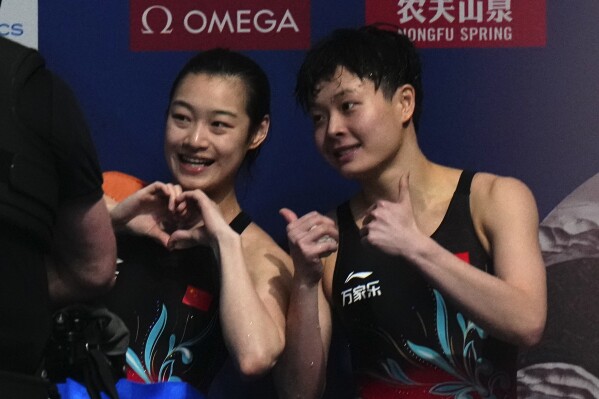 Chang Yani of China, left, and Chen Yiwen of China gesture after winning gold and silver during the women's 3m springboard diving final at the World Aquatics Championships in Doha, Qatar, Friday, Feb. 9, 2024. (AP Photo/Hassan Ammar)