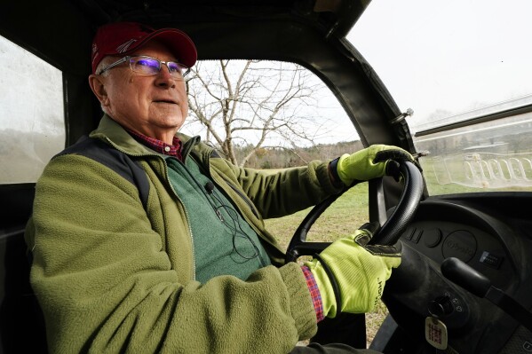 Trailer park owner Ed Smith drives a four-wheeler at Stearns Park, Wednesday, Nov. 15, 2023, in Hinsdale, N.H. Smith is one of the trustees in charge of a $3.8 million gift to the town from his friend Geoffrey Holt. (AP Photo/Robert F. Bukaty)