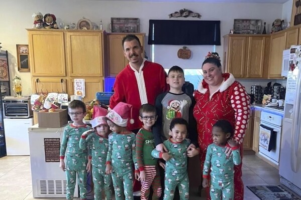 In this photo provided by Karen Lopez, she and her husband, Jerry Lopez, are seen with their seven children in December 2023. Jerry Lopez, 39, was killed in Las Vegas two days after Christmas while on his way to work in what Las Vegas police say was the final carjacking in a crime spree. (Karen Lopez via AP)