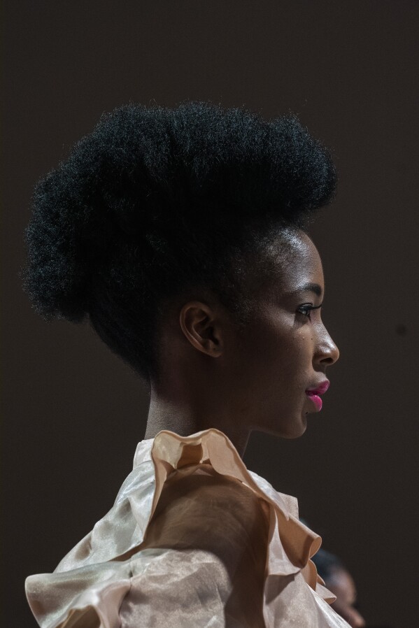 A model display a garment donated by selected designers for the "Design for Life" showcase opening the Johannesburg Fashion Week 2023 in Johannesburg, South Africa, Wednesday, Nov. 8, 2023. The primary objective of this show was to raise awareness for breast cancer, and many of the models were breast cancer survivors. (AP Photo/Jerome Delay)