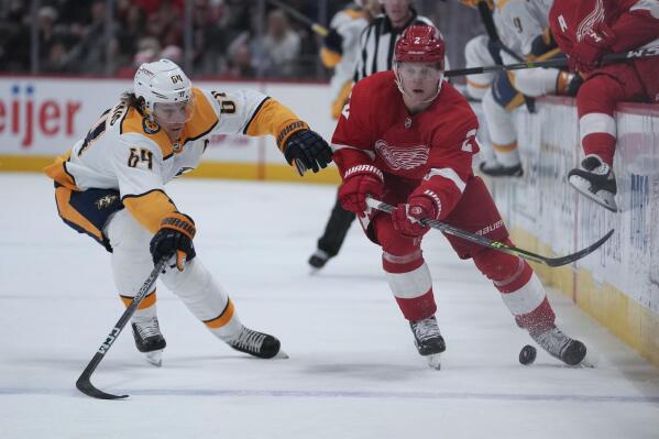 Detroit Red Wings defenseman Olli Maatta (2) passes as Nashville Predators center Mikael Granlund (64) defends in the second period of an NHL hockey game Wednesday, Nov. 23, 2022, in Detroit. (AP Photo/Paul Sancya)