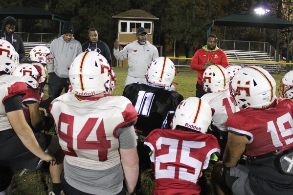 This photo provided by the University of Maryland shows Terrence Byrd, president of Maryland Heat, a youth tackle football program, speaking to players after practice in Fort Washington, Md., Nov. 9, 2023. Tackle football offers children as young as 5 the chance to make friends, learn teamwork and maybe win a college scholarship. Growing research shows it also can cause injuries that damage developing brains. (University of Maryland/Torrence Banks via AP)