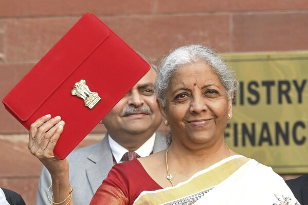 Indian Finance Minister Nirmala Sitharaman shows a red pouch containing budget documents, as she arrives to present the federal budget in the Parliament in New Delhi, India, Saturday, Feb. 1, 2025. (AP Photo)