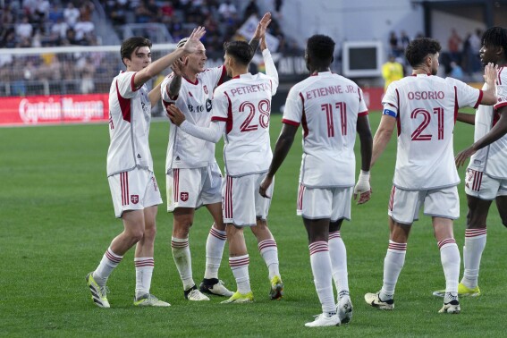 Toronto FC forward Federico Bernardeschi (10) celebrates with his teammates after his goal against D.C. United during the first half of an MLS soccer match Saturday, June 1, 2024, in Washington. (AP Photo/Jose Luis Magana)