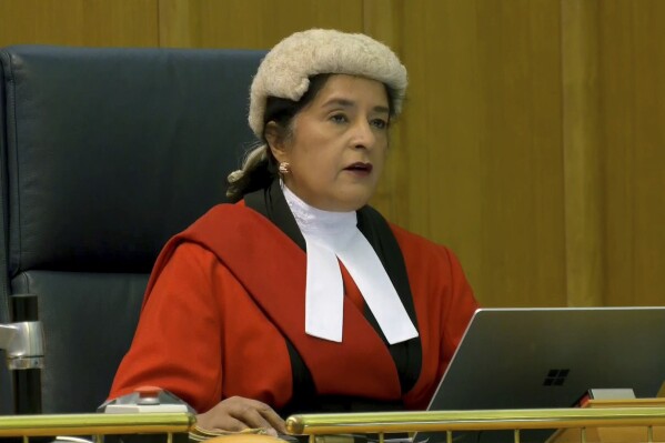 This screen grab taken from PA Video shows judge Mrs Justice Cheema-Grubb, during a live broadcast from Teesside Crown Court, sentencing Moroccan asylum seeker Ahmed Alid, 45, who was found guilty of murdering Terence Carney, attempting to murder his own housemate and assaulting two police officers, to life with a minimum term of 45 years, at the court in London, Friday May 17, 2024. (PA Video/PA via AP)