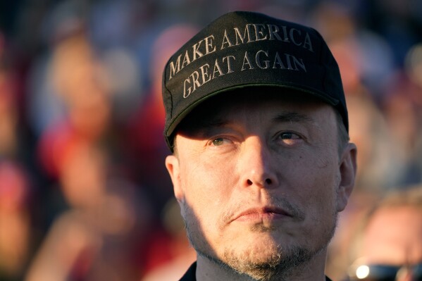 Tesla and SpaceX CEO Elon Musk listens as Republican presidential nominee former President Donald Trump speaks at a campaign event at the Butler Farm Show, Oct. 5, 2024, in Butler, Pa. (AP Photo/Alex Brandon, File)
