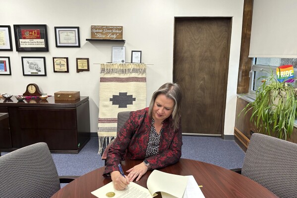 This Dec. 13, 2023, image provided by the New Mexico State Land Office shows Land Commissioner Stephanie Garcia Richard in her office in Santa Fe, New Mexico, signing an executive order extending a moratorium on new oil and gas leasing in state trust land surrounding the Chaco Culture National Historical Park. Garcia Richard and Native American leaders celebrated the signing of the order during a virtual call on Thursday, Dec. 14, 2023. (New Mexico State Land Office via AP)