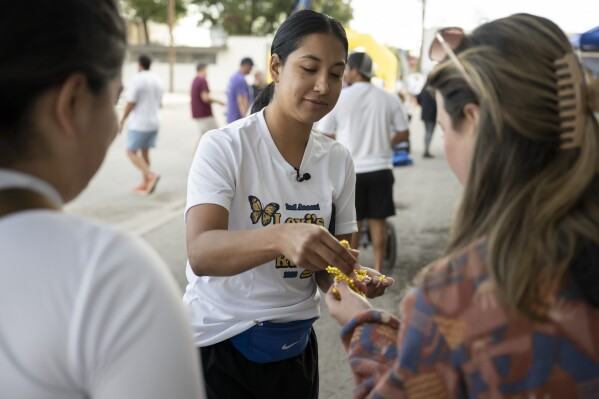 Uvalde mayoral candidate Kimberly Mata-Rubio, center, hands out bracelets before the second annual Lexi's Legacy Run, Saturday, Oct. 21, 2023, in Uvalde, Texas. (AP Photo/Darren Abate)