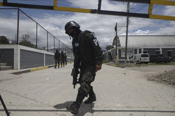 Military police guard the entrance to the National Penitentiary Center in Tamara, on the outskirts of Tegucigalpa, Honduras, Tuesday, June 26, 2023. Honduran President Xiomara Castro has put the military police in charge of the country's poorly-run prisons as the Central American country adopts El Salvador-style tactics in an anti-gang crackdown on prison inmates. (AP Photo/Elmer Martinez)
