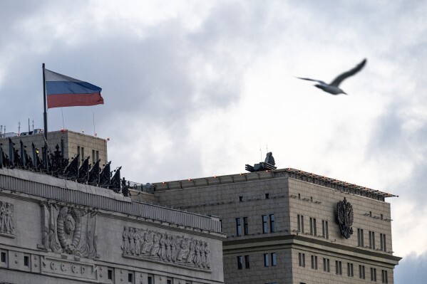 FILE - A bird flies over the building of the Russian Defense Ministry with anti-aircraft artillery systems atop the roof in Moscow, early Saturday, June 24, 2023. A week after the mutiny raised the most daunting challenge to President Vladimir Putin’s rule in over two decades, key details about the uprising remain shrouded in mystery. (AP Photo, File)