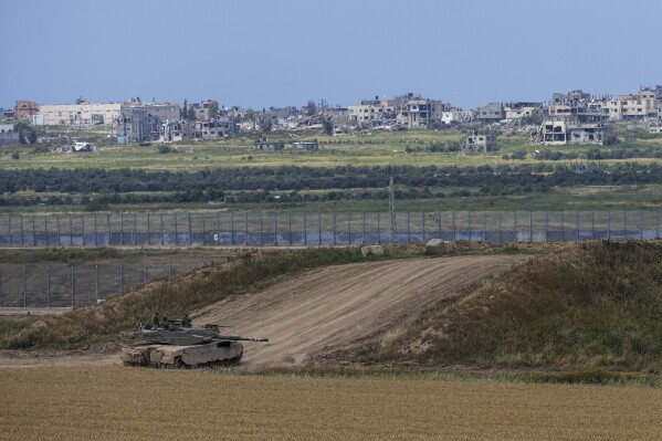 Israeli soldiers rest on top of their tank on the border with the Gaza Strip, in southern Israel, Monday, April 8, 2024. (AP Photo/Tsafrir Abayov)