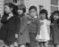 In this photo provided by the National Archives, first grade students pledge allegiance to the flag at Raphael Weill Public School at Geary and Buchanan Streets in San Francisco on April 20, 1942. Many children of Japanese ancestry attended the school, but were relocated to an internment camp for Japanese Americans. (Dorothea Lange/War Relocation Authority/National Archives via AP)