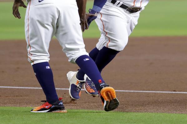 Houston Astros third base coach Gary Pettis (8) low fives Jose Altuve, right, as he rounds third base on his home run during the first inning of a baseball game Tuesday, Sept. 27, 2022, in Houston. (AP Photo/Michael Wyke)
