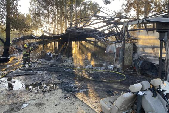 This photo provided by the City of Redlands shows the burned remains of a structure fire where firefighters discovered an illegal marijuana cultivation operation with thousands of plants in Redlands, Calif., Wednesday, Nov. 24, 2021. Authorities said they found more than 11,000 marijuana plants at an illegal growing operation after one of the buildings caught fire. Marijuana plants were found in the second building and thousands more were in a third building that wasn't damaged. Police say all of it will be destroyed. (Redlands Fire Department via AP)
