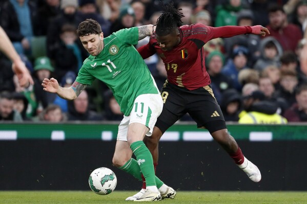 Ireland's Robbie Brady, left, and Belgium's Johan Bakayoko challenge for the ball during the international friendly soccer match between Ireland and Belgium at the Aviva Stadium in Dublin, Ireland, Saturday, March 23, 2024. (AP Photo/Peter Morrison)