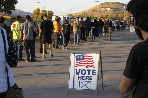 FILE - People wait to vote in-person at Reed High School in Sparks, Nev., prior to polls closing on Nov. 3, 2020. An election-fraud crusader in Nevada has withdrawn his latest federal lawsuit in an ongoing feud with county officials in Reno after their lawyers threatened to seek sanctions for filing a baseless complaint laced with “rantings of a conspiracy theorist." (AP Photo/Scott Sonner, File)
