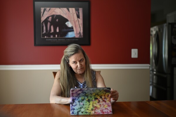 Rep. Jennifer Wexton, D-Va., uses an AI program on her iPad at her home in Leesburg, Va., Friday, July 19, 2024. A rare neurological disease robbed Wexton of her ability to speak clearly. But with the help of a powerful artificial intelligence program, the Virginia Democrat will use a clone of her voice to deliver what is believed to be the first speech on the House floor ever given via a voice cloned by artificial intelligence, thrusting Wexton into a broader debate about over artificial intelligence. (AP Photo/John McDonnell)