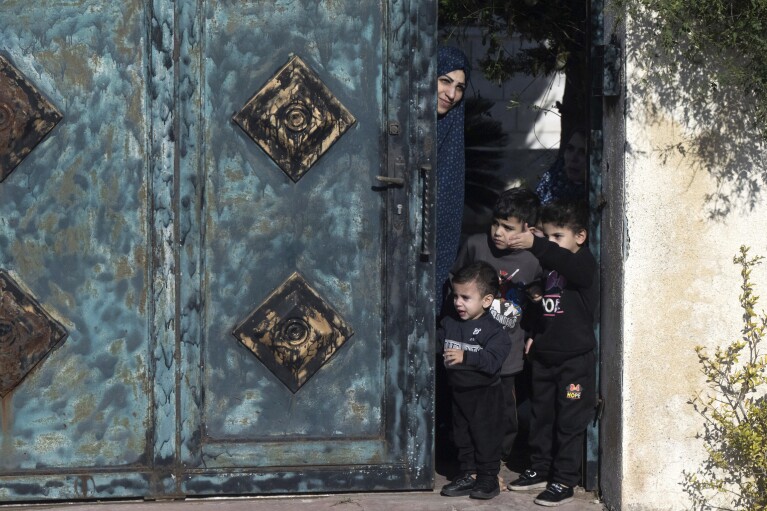 As pessoas assistem enquanto a carreata do secretário de Estado dos EUA, Anthony Blinken, passa pela Cisjordânia após uma reunião com o líder da Autoridade Palestina na cidade de Ramallah, na Cisjordânia, quinta-feira, 30 de novembro de 2023.  (Saul Loeb/Foto da piscina via AP)